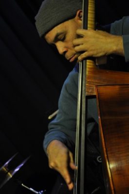 Calvin Jones in a woollen hat, playing the bass.